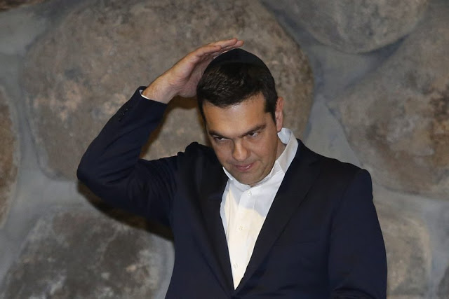 epa05040966 Greek Prime Minister Alexis Tsipras puts on a skullcap (Kipa) in the 'Hall of Remembrances' at the Yad Vashem Holocaust memorial museum in Jerusalem, 25 November 2015 during a ceremony honoring the six-million Jews who perished at the hands of the Nazis during the Holocaust of World War II. Alexis Tsipras is on an official visit to Israel.  EPA/ABIR SULTAN